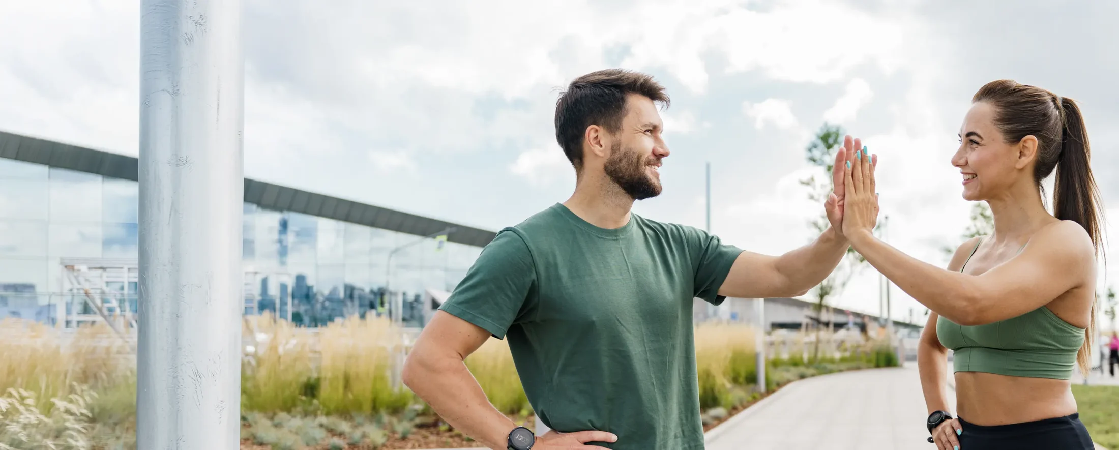 Man and woman high fiving out doors